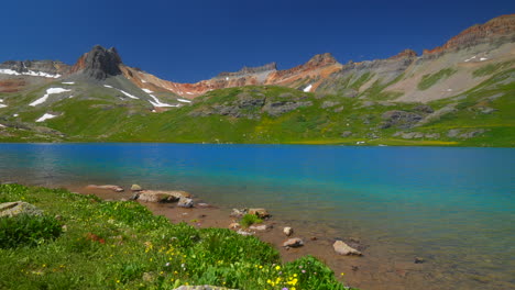 colorado ice lake basin trailhead lower stunning bright blue alpine clear water summer blue sky rocky mountain snow range peaks silverton telluride dreamy peaceful wildflowers slow pan left motion