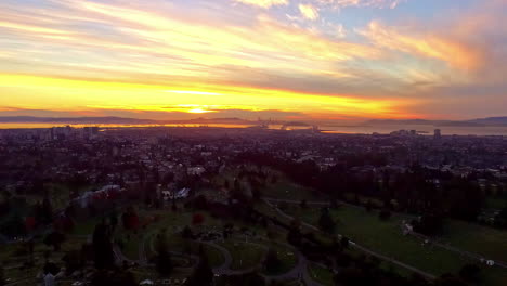 Aerial-wide-shot-showing-golden-sunset-above-San-Francisco-Cityscape,-America