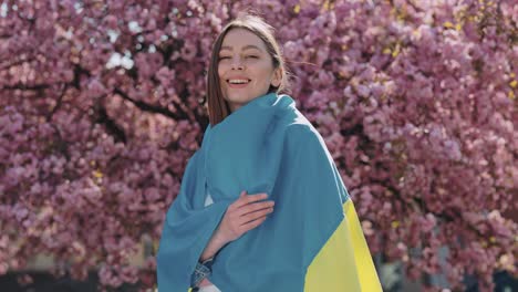 woman with ukrainian flag in a cherry blossom tree