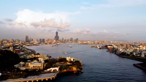 Vista-De-La-Hora-Dorada-De-Un-Bullicioso-Puerto-De-La-Ciudad-Con-Barcos-Y-Horizonte,-Perspectiva-Aérea