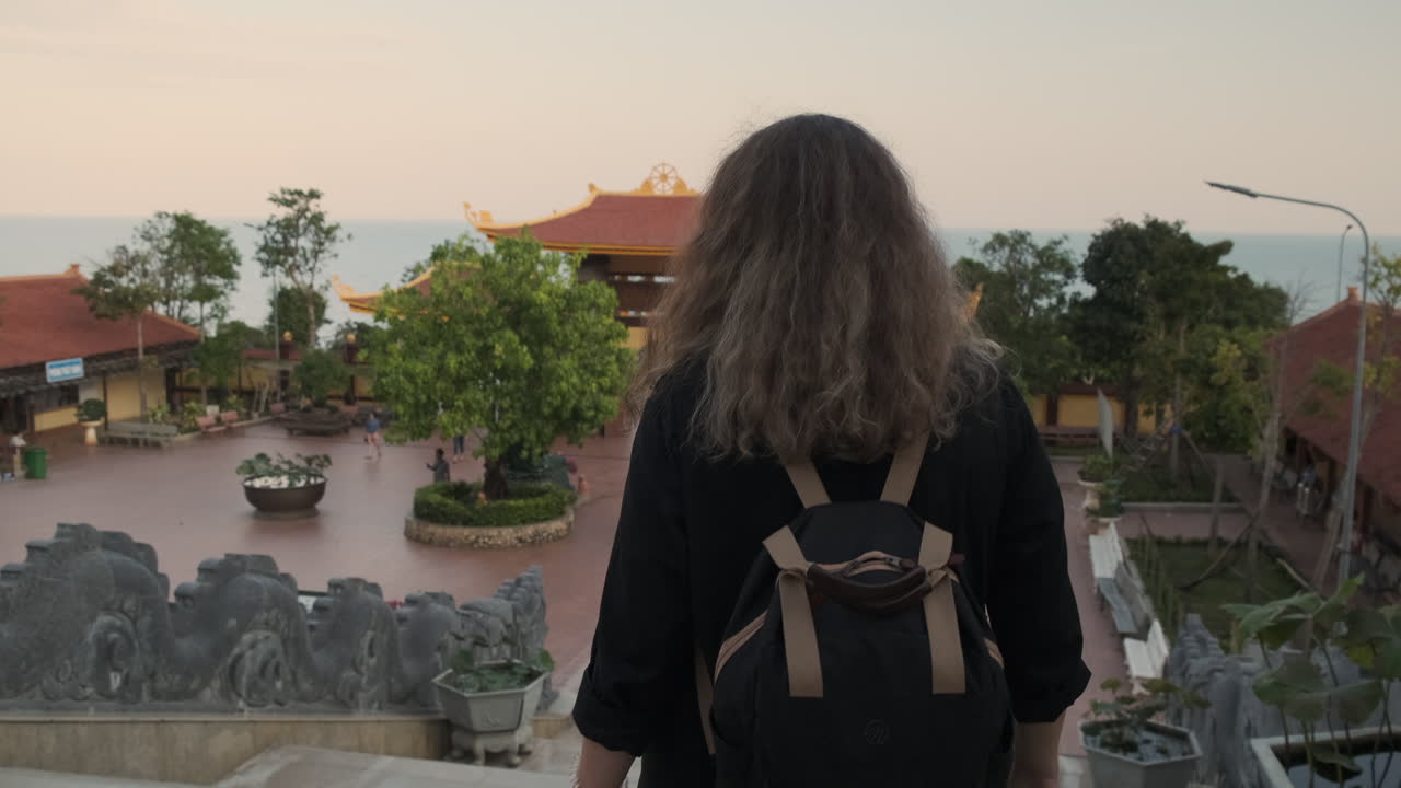 Woman Walking Through a Buddhist Temple Complex