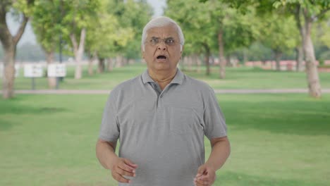 Sad-Indian-old-man-watching-something-shocking-in-park