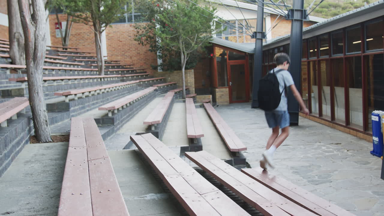 Running through school courtyard, child enjoying outdoor activity after school, copy space