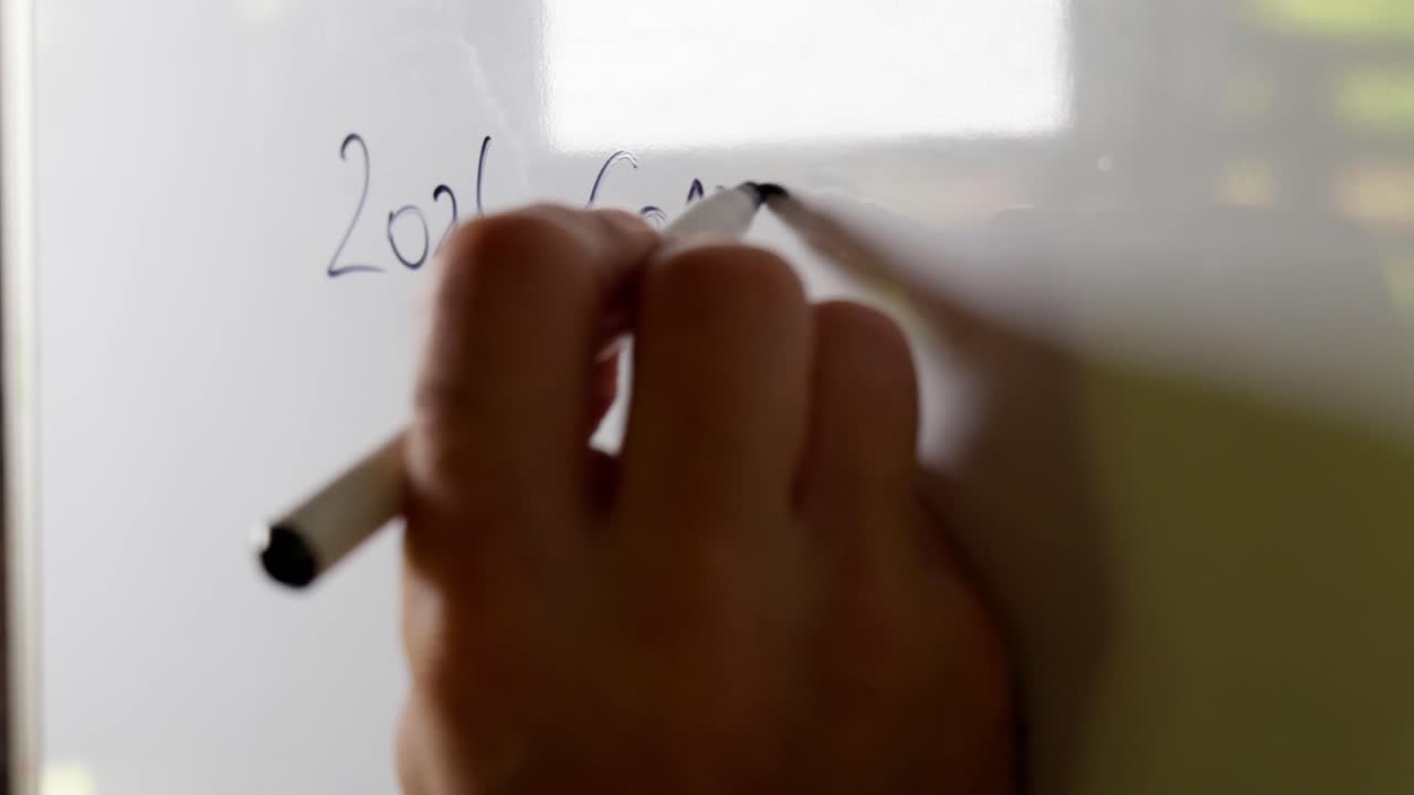 Man planning out 2026 goals on a whiteboard, close in shot, clip 2