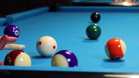 Hitting-white-ball-against-green-ball-in-a-game-of-pool-billiards