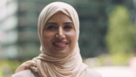 portrait of muslim businesswoman outdoors standing in front of city offices 2