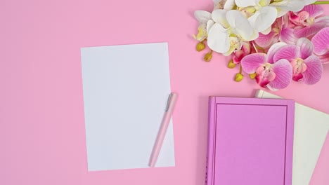 white paper for writing and romantic flowers and books appear on pastel pink theme. stop motion animation