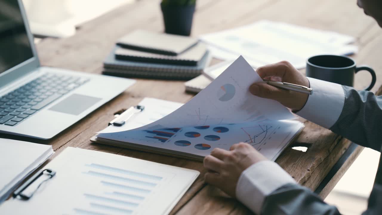 Businessman working on Desk office with marketing graph statistics analysis, Financial and tax systems concept.