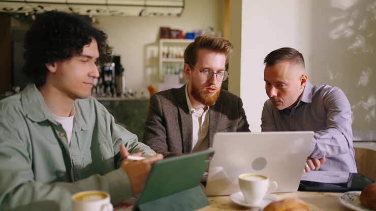 Three colleagues working together at a cafe