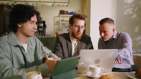 three colleagues working together at a cafe