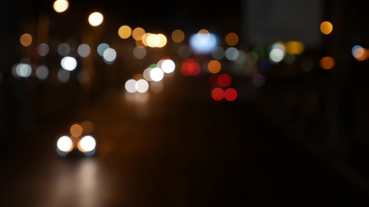 hermoso bokeh brillante en el fondo oscuro borroso por la noche. el redondo bokeh colorido brilla de las luces de los coches en la calle de la ciudad. fuera de foco con borroso. luces de la ciudad sin enfoque. bokeh de tráfico. concepto abstracto