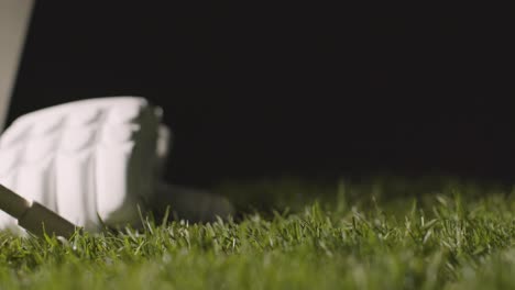 cricket still life with close up of bat ball bails and gloves lying in grass