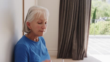 Sitting by window, elderly woman reflecting quietly at home in peaceful moment