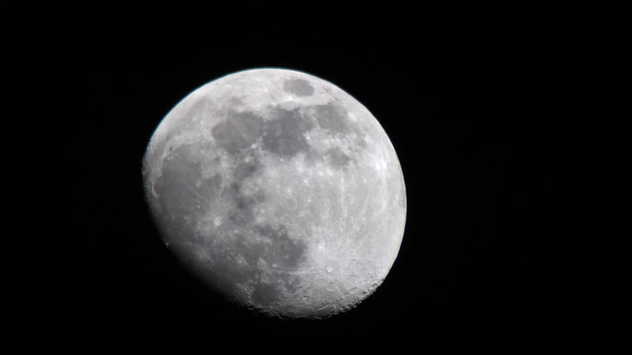 Vista detalhada da Lua em Quarto Minguante movendo-se na escuridão da noite.
