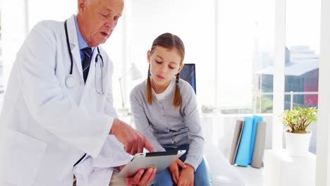 Male-doctor-discussing-with-girl-over-digital-tablet