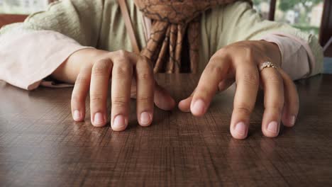 close-up of woman's hands on wooden table