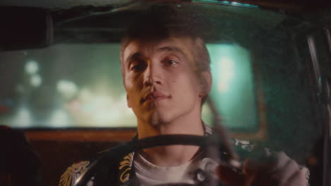 taxi driver driving vintage cab during rainy night in city