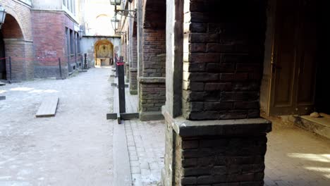 a-row-of-red-and-white-brick-buildings-lined-up-in-a-row-on-a-sidewalk-next-to-a-white-streetlight-casting-a-warm-glow-on-the-buildings-at-dusk-or-dawn