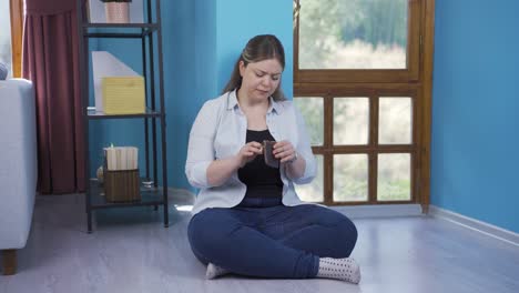 The-young-woman-sitting-by-the-wall-looks-at-her-empty-wallet.-Broke.