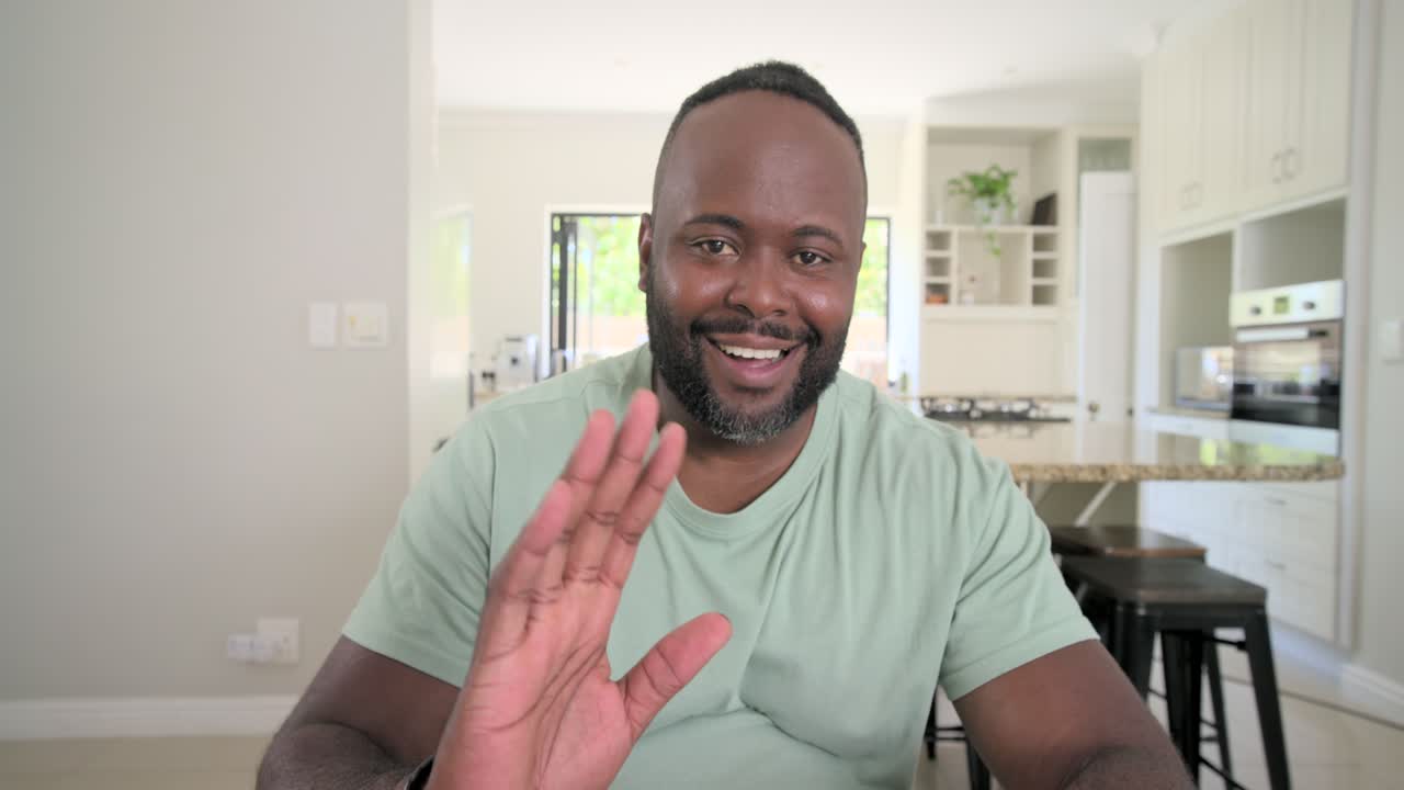 mid-30s African American man typing on laptop at kitchen table, finishing and presenting to camera