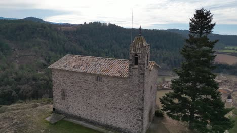 Historic-church-in-the-Old-Town-of-Oristas,-Barcelona-surrounded-by-scenic-rolling-hills