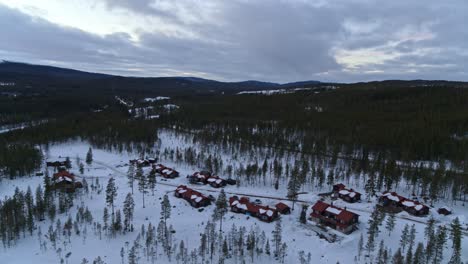 dolly shot of a drone flying over the wintry landscape of the little village fulufjallsbyn in northern europe, sweden