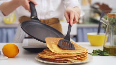 anonymous cook putting a pancake on top of another pancake