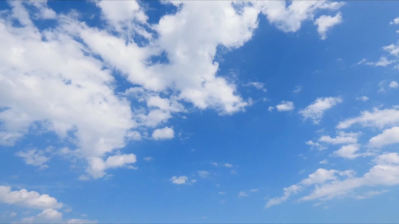 Timelapse di nuvole che si muovono in un cielo azzurro brillante, mostrando il movimento atmosferico naturale e il cambiamento del tempo in una tranquilla scena all'aperto.
