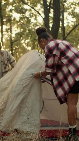 Woman Setting Up Tent in Forest at Sunrise/Sunset