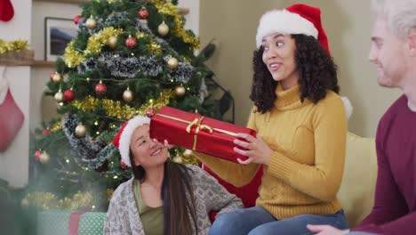 un grupo feliz y diverso de amigos compartiendo regalos en la época de navidad