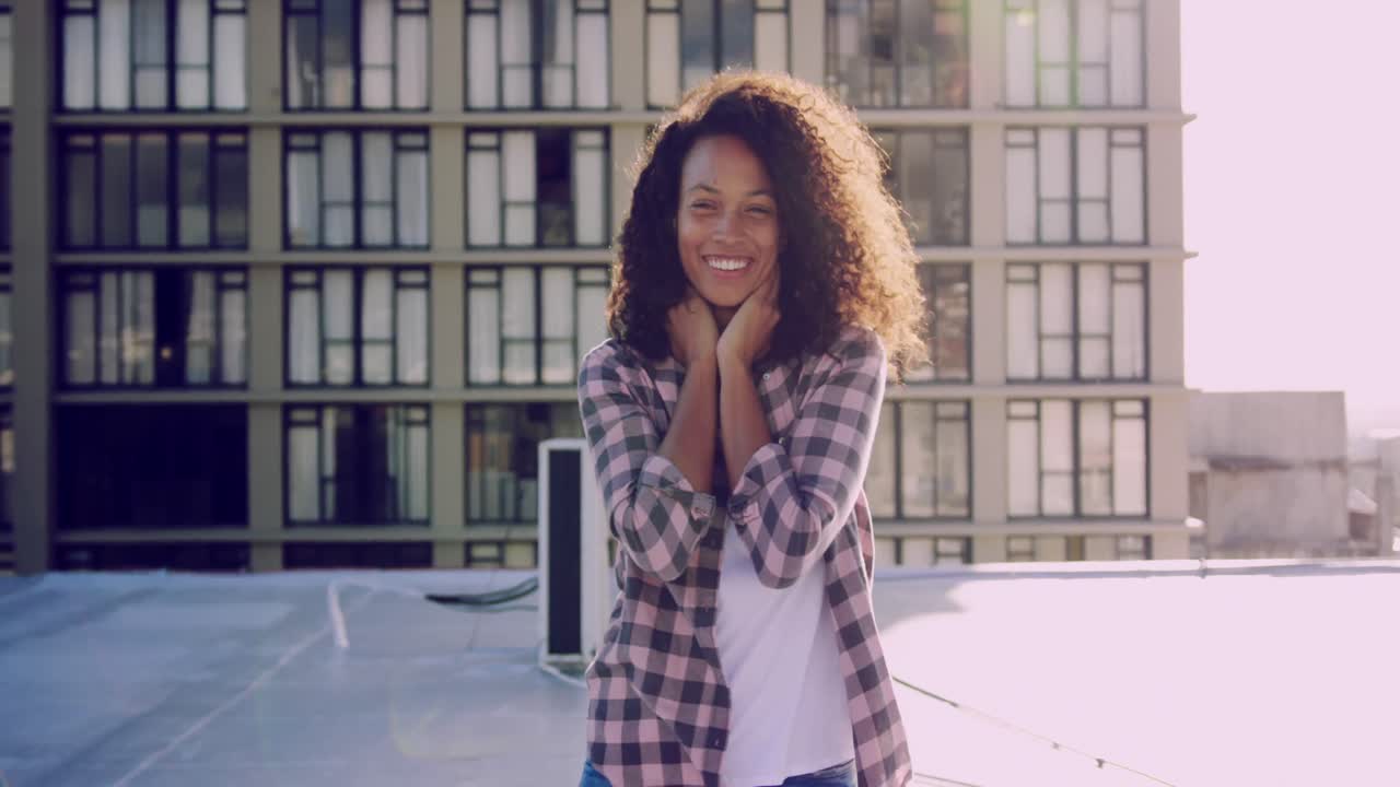 Giovane donna alla moda su un tetto urbano