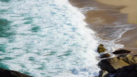 pure emerald sea waves washing golden sand with foam close up, tranquil scene