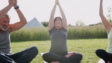 Lehrerin-Leitet-Eine-Gruppe-Reifer-Männer-Und-Frauen-Im-Unterricht-Bei-Einem-Yoga-Retreat-Im-Freien