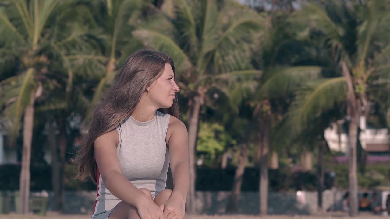 녹색 손바닥에 맞춰 긴 여름 드레싱을 입은 젊은 여성