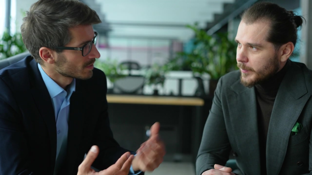 To professionelle forretningsmænd diskuterer strategi på et moderne kontor.
