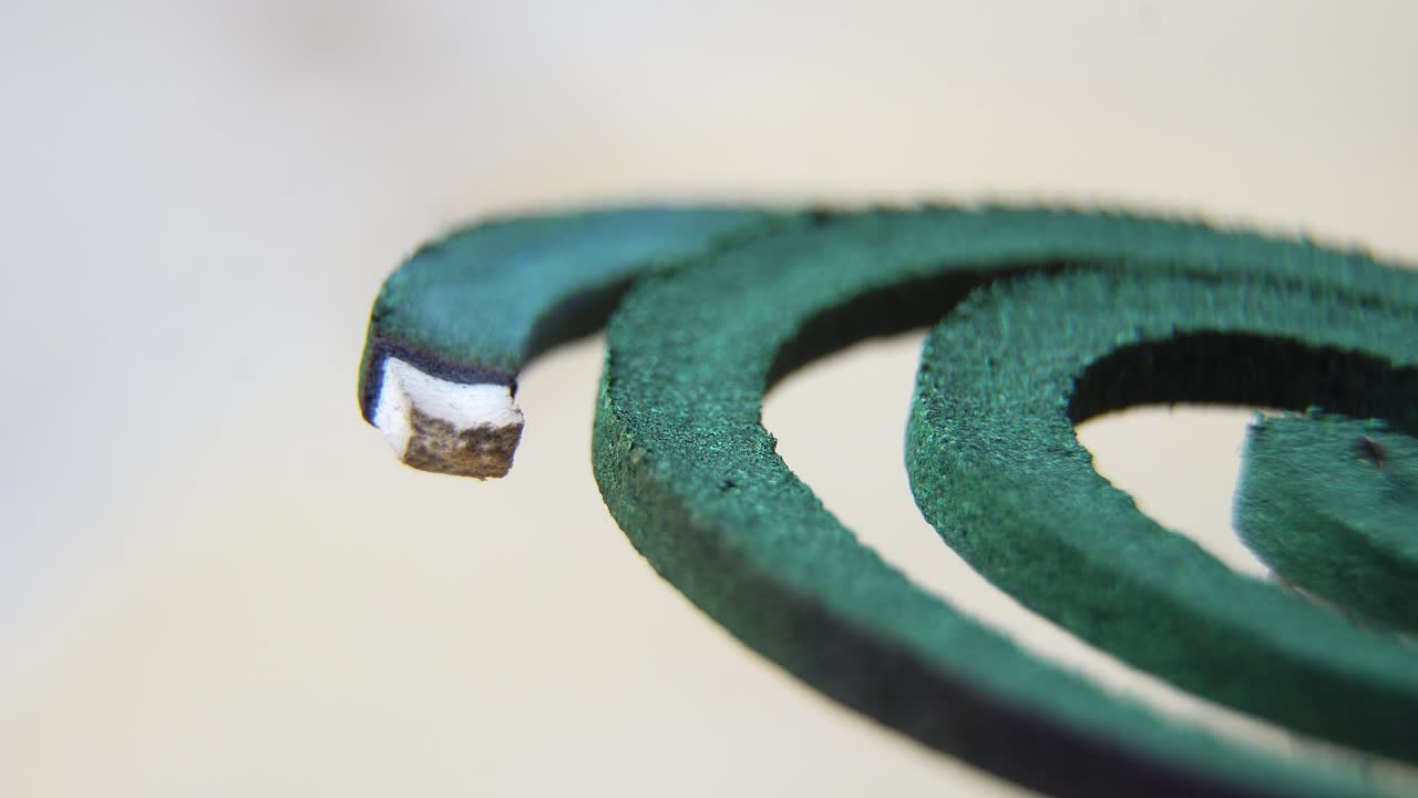 Close-up of a burning mosquito coil against a clear background