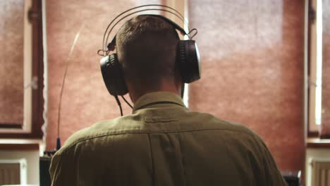 military radio operator using headphones before speech, back view of head