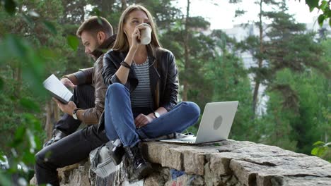 young couple sitting on stone bridge