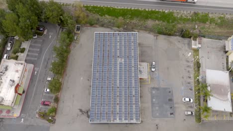 Vista-Aérea-A-Vista-De-Pájaro,-Gran-Matriz-De-Paneles-Solares-En-La-Azotea-Del-Edificio-Comercial