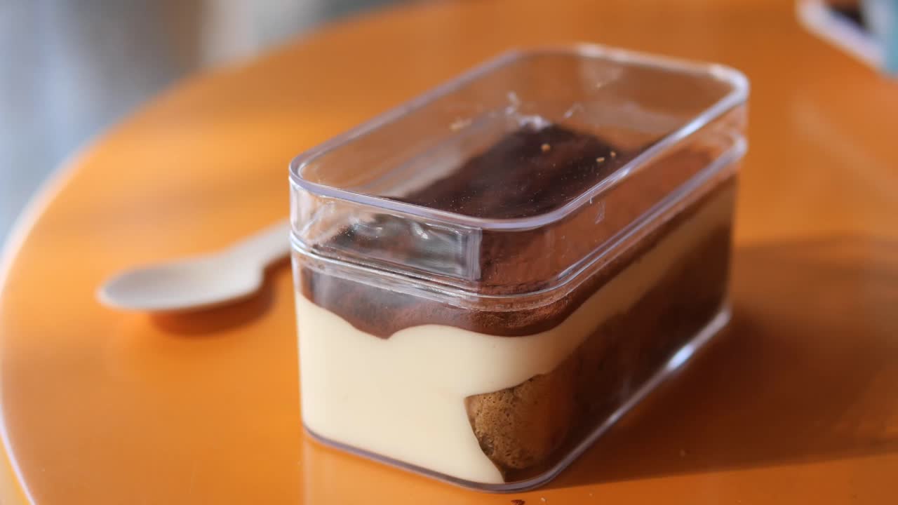 Tiramisu in a container with a spoon