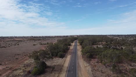 Dron-Volando-Sobre-Una-Carretera-Vacía-En-Un-Paisaje-Desértico