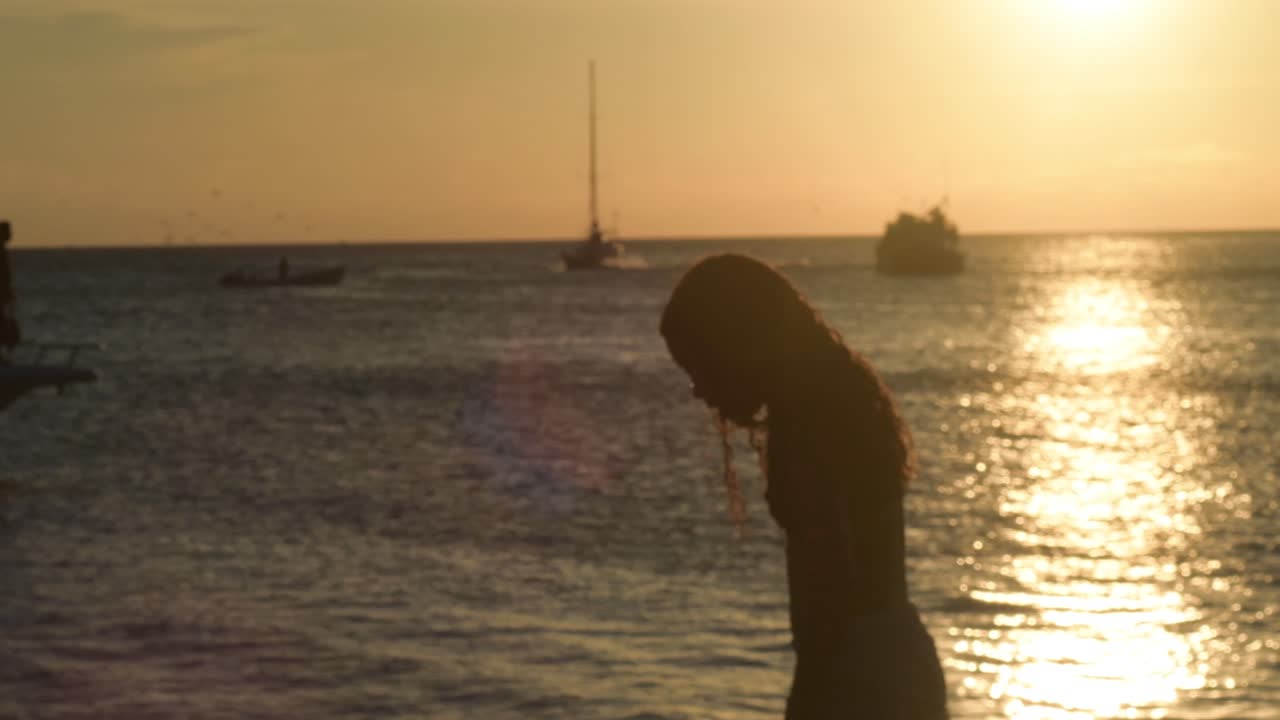 Silhouetted shot of a people on pier at sunset, close up, Los Roques Venezuela