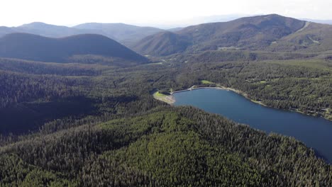 Drone-shot-of-green-mountains-and-a-lake