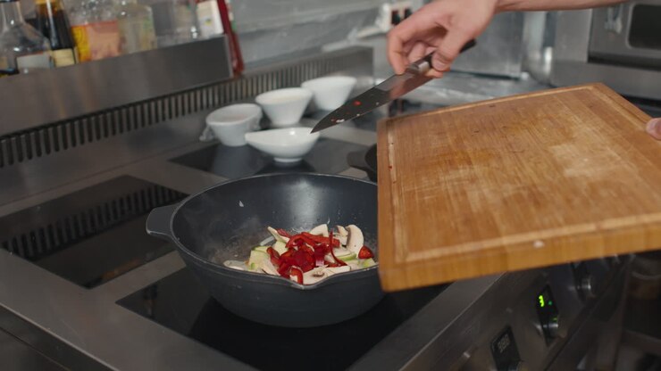 Friggere verdure in una padella wok