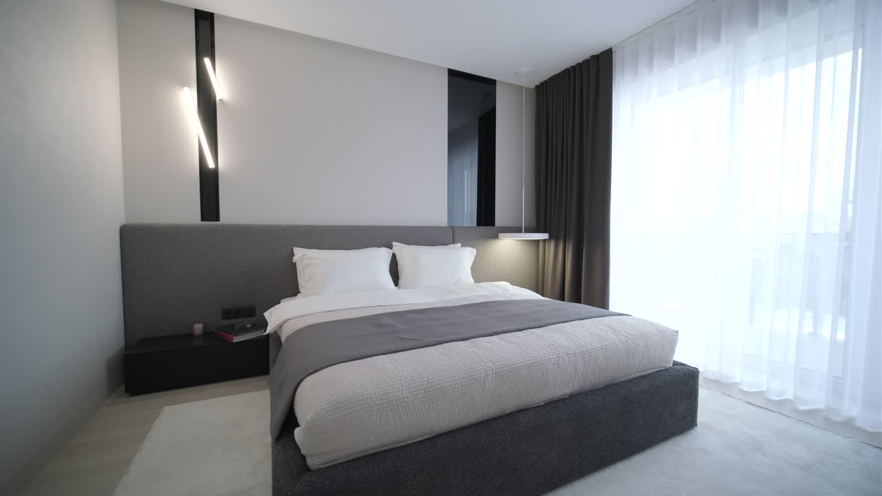 Stilfuldt moderne soveværelse med stor seng og minimalistisk indretning