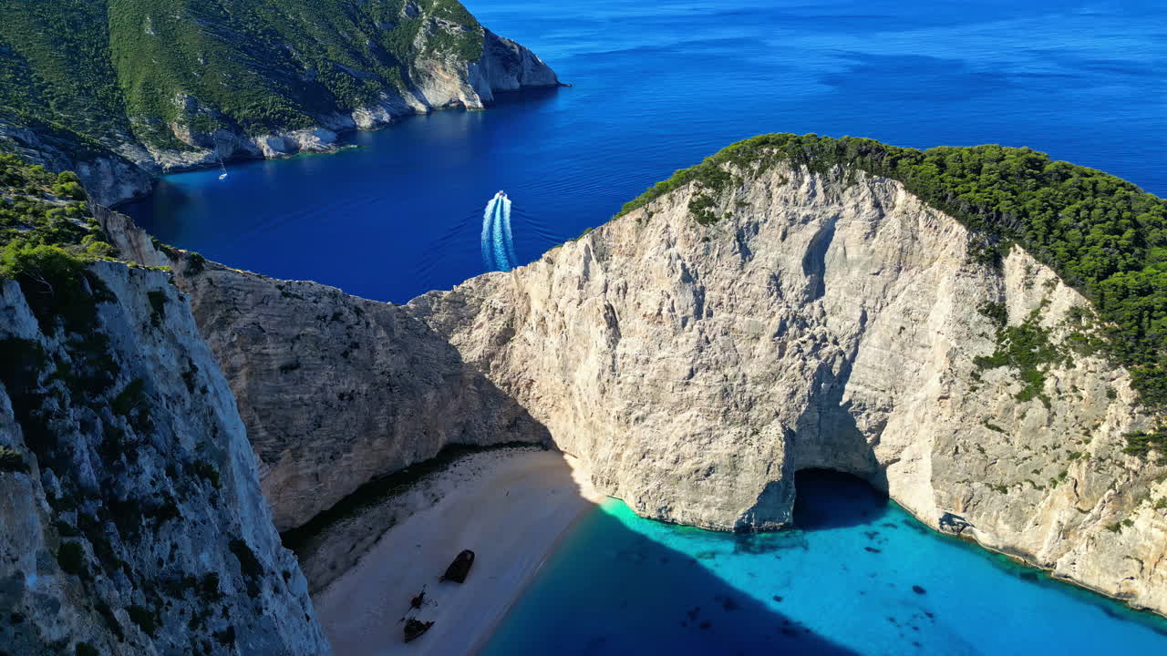 la playa de navagio en grecia con un naufragio, aguas azules y altos acantilados vistos desde arriba