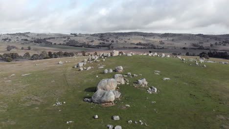 aerial forward moving shot over top of huge boulders on hill