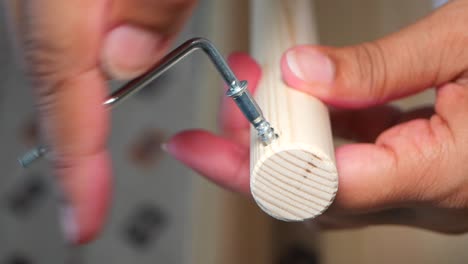 close-up of a person installing a screw into wood