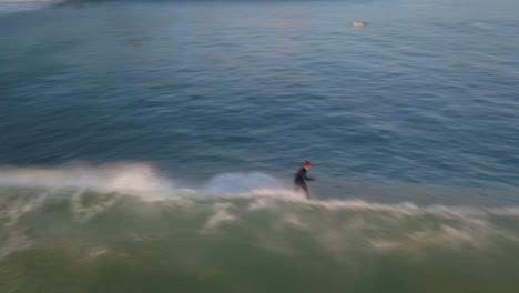 vista aérea de un surfista experto genera una velocidad increíble mientras maniobran hábilmente a través de las olas, sin esfuerzo recortando y deslizándose con una velocidad impresionante en la playa de estoril, cascais