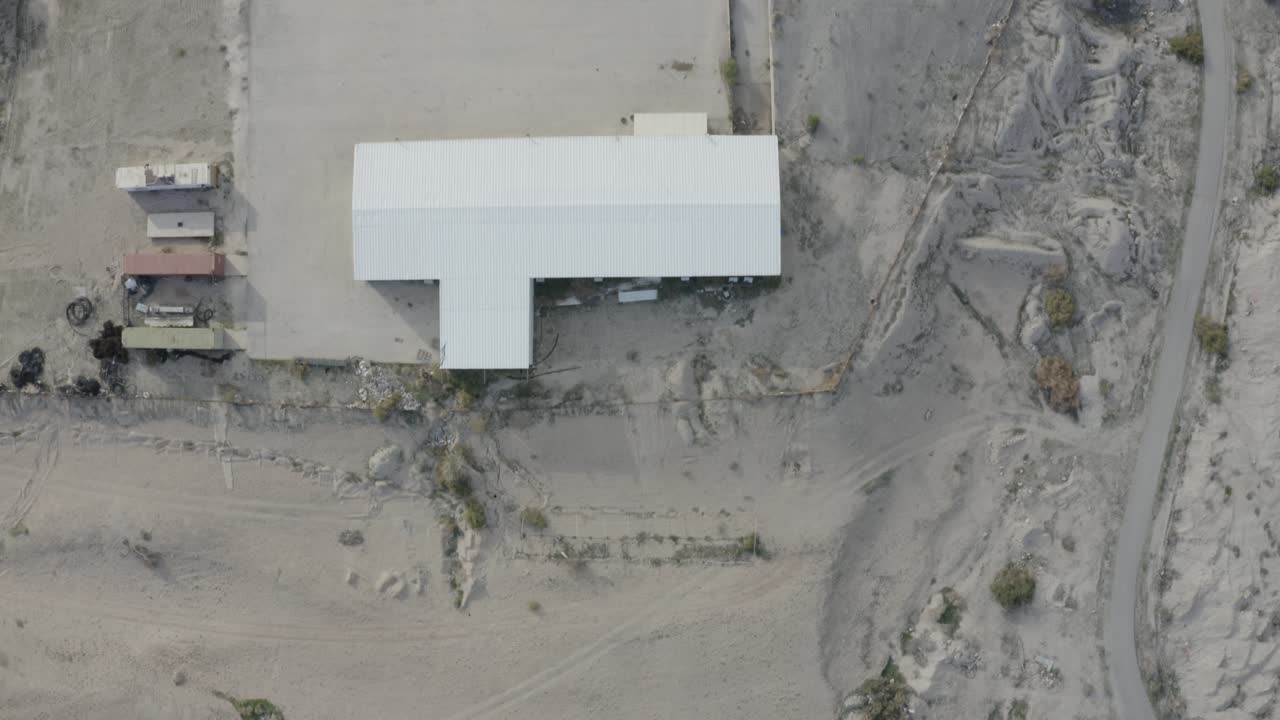 vista aérea superior de un único edificio aislado con techo blanco en el desierto, israel